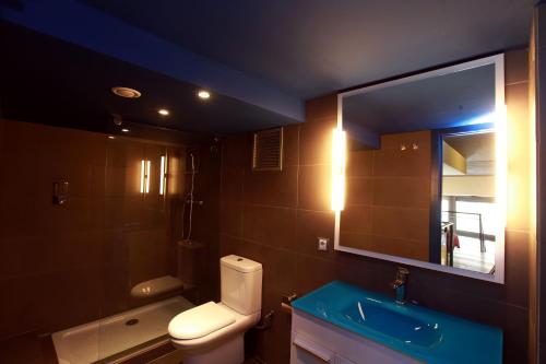 a bathroom with a toilet and a sink and a mirror at Alojamiento ciudad las artes in Valencia
