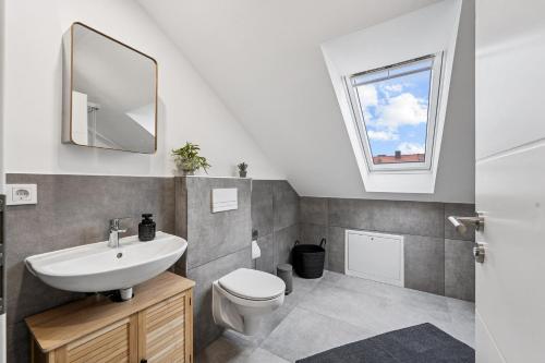 a bathroom with a sink and a toilet and a window at Yello Homes - 4 Gäste - 2 Zimmer - Großartiger Blick in Herzogenaurach