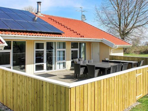 a house with a table and a solar roof at Luxury Pool House by Sea - By Traum Ferienwohnungen in Nordborg