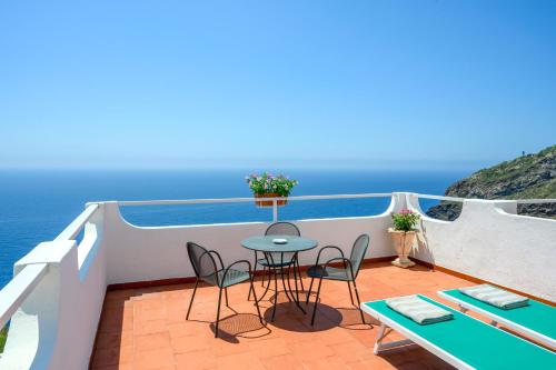 a balcony with a table and chairs and the ocean at Hotel Grazia alla Scannella in Ischia