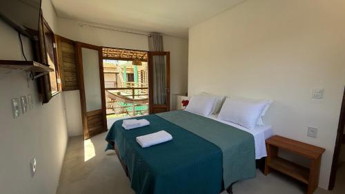 a bedroom with a bed with two towels on it at Chalé Sol Nascente Milagres in São Miguel dos Milagres