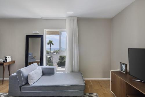Una sala de estar con un sofá y un televisor. en NEA Resort & People, en Shave Ẕiyyon