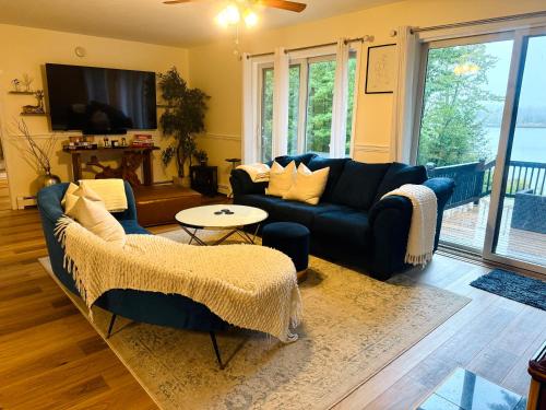 a living room with blue couches and a tv at The Blue Lotus in New Durham