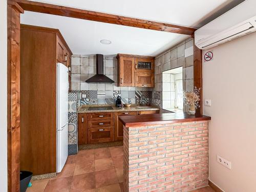 a kitchen with wooden cabinets and a brick wall at Apartamento La Plaza in Munera