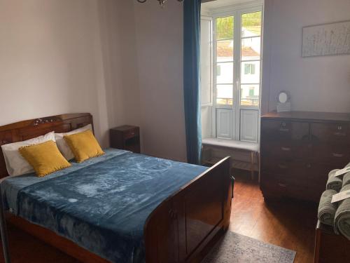 a bedroom with a bed with yellow pillows and a window at Botânico Guesthouse in Nordeste