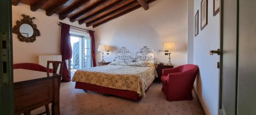 a bedroom with a bed and a red chair at Relais I Due Roccoli in Iseo