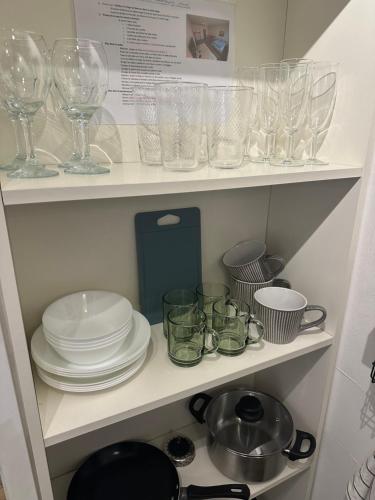 a cupboard filled with glasses and plates and dishes at Centrally located apartment Luxembourg in Luxembourg