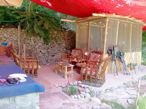 un patio con sillas, una mesa y una tienda de campaña en Cottage De Hunza- A Soul Retreat Sanctuary, en Hunza