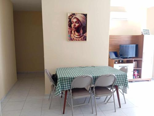 Un comedor con una mesa y un cuadro en la pared. en Casa Mendes, en São Filipe