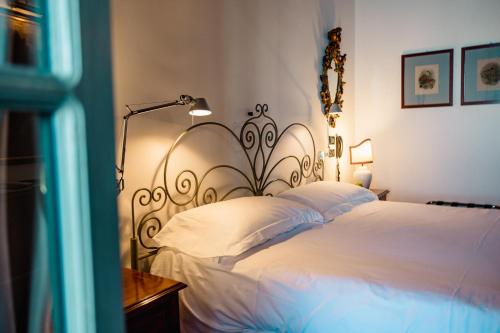 a bedroom with a large bed with white sheets at Relais I Due Roccoli in Iseo