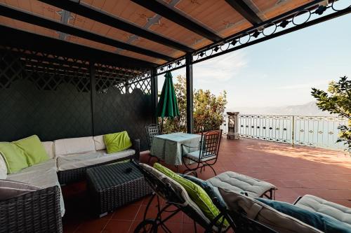 a patio with a couch and chairs on a deck at Relais I Due Roccoli in Iseo