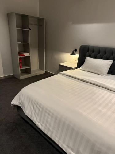 a bedroom with a large white bed and a shelf at Studio Comfort in Jeddah