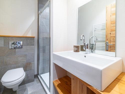 Un baño con un lavabo blanco y un inodoro. en Appartement rénové au coeur de Mônetier-les-Bains avec services inclus - FR-1-808-14, en Le Monêtier-les-Bains