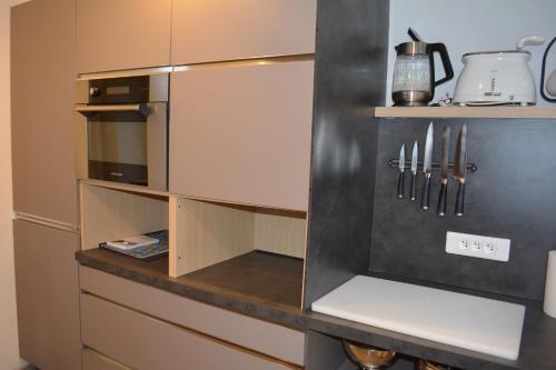 a kitchen with a cupboard with knives in it at Appartement-terrasse parking privé Meublé de Tourisme 4 étoiles in Belfort