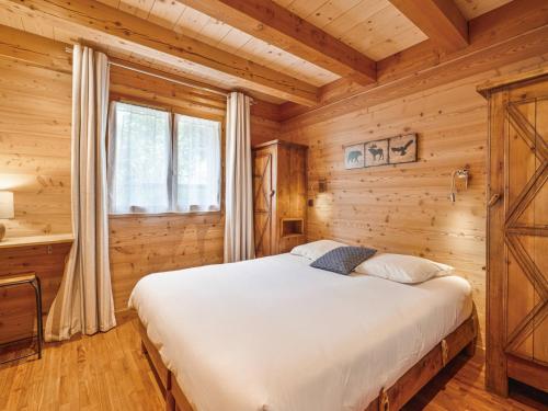 a bedroom with a bed in a log cabin at Chalet lumineux avec jacuzzi et salle de jeux - FR-1-808-1 in Le Monêtier-les-Bains