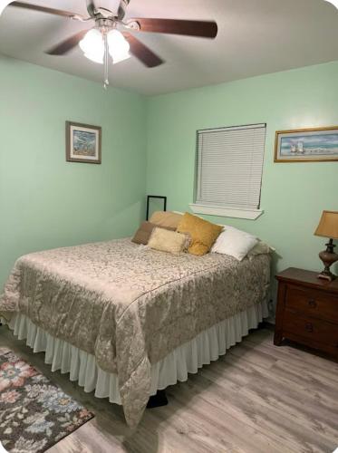 Un dormitorio con una cama y un ventilador de techo. en Rivertown Bungalow, 