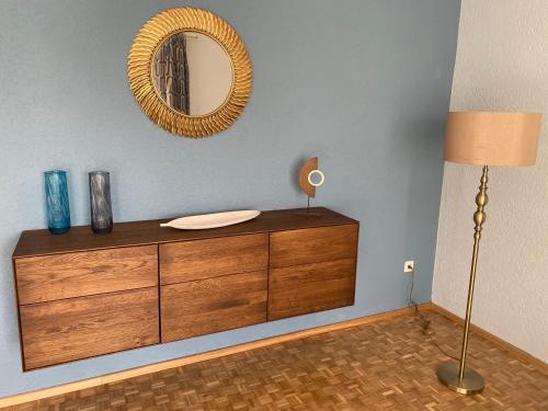 a room with a dresser and a mirror on a wall at Moderne 2 Zimmer Wohnung in bester Lage - ruhig, zentral, stilvoll in Abensberg