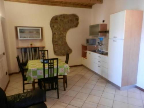 a kitchen with a table and a kitchen with a refrigerator at Appartasmento Ficus in bedizzol