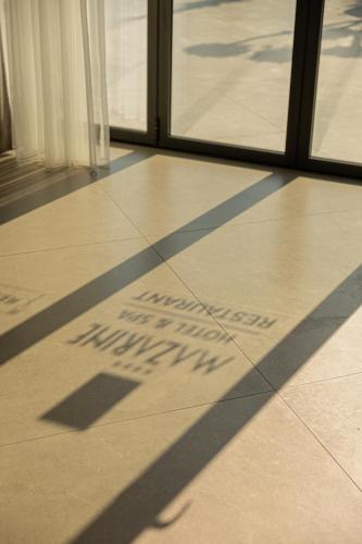 a shadow of a sign on the floor of a building at Mazarine Hotel, Vlorë, Albania in Vlorë