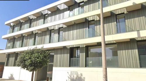 an office building with a tree in front of it at LUX BeACH in Praia da Barra