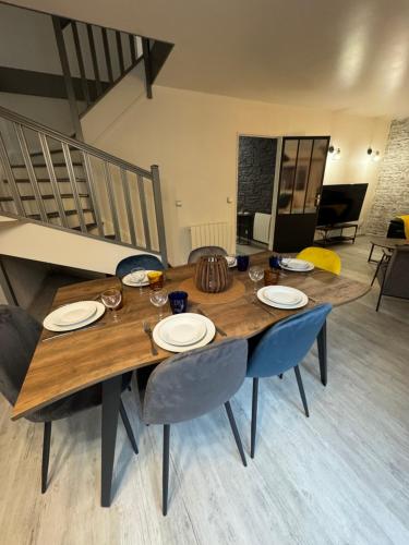 einem Holztisch mit Stühlen und Tellern darauf in der Unterkunft Stelorevan in Bailly-Romainvilliers