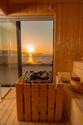 a sauna with a fireplace with a sunset in the window at Mazarine Hotel, Vlorë, Albania in Vlorë