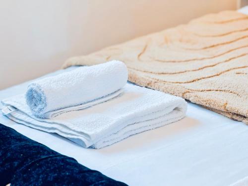 a pile of towels sitting on top of a bed at Elegant 1 bed flat, Sleeps 4, Free parking, Pet friendly, Pudsey, Leeds in Pudsey