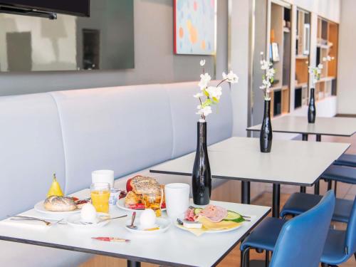 a table with breakfast foods and drinks on it at B&B Hotel München City-Ost in Munich