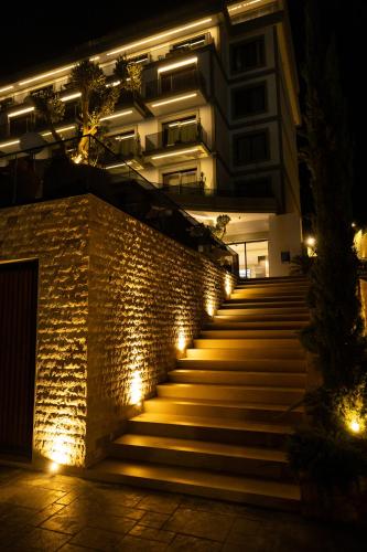 a staircase leading to a building at night with lights at Mazarine Hotel, Vlorë, Albania in Vlorë