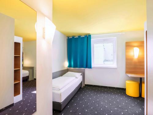 a small room with a bed and a window at B&B Hotel Ludwigshafen in Ludwigshafen am Rhein