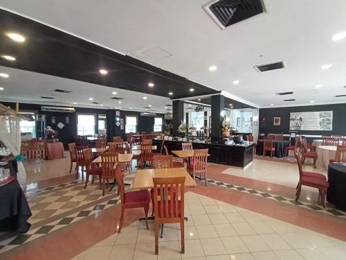 a restaurant with tables and chairs and a cafeteria at Hotel Seri Malaysia Kulim in Kulim