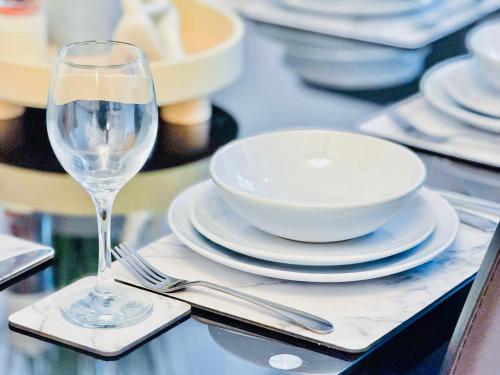 a table with plates and a wine glass on it at Elegant 1 bed flat, Sleeps 4, Free parking, Pet friendly, Pudsey, Leeds in Pudsey