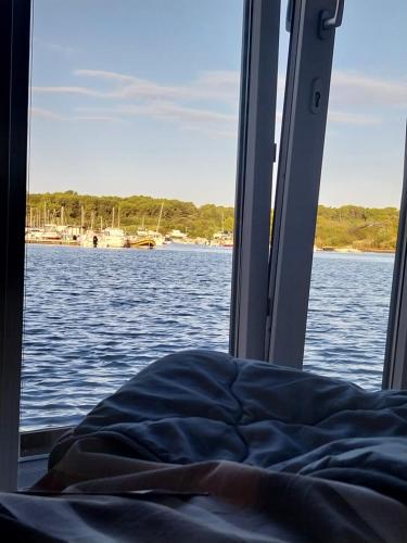 a bed on a boat on a body of water at Floating House - LUXURY Floating Sea OASIS Pula in Pula