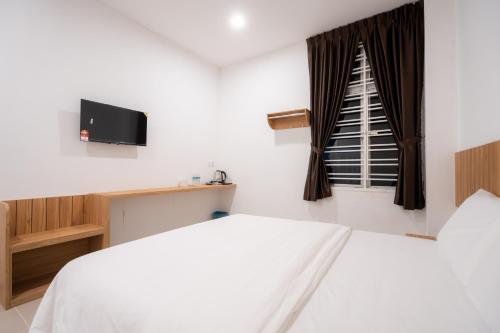 a bedroom with a white bed and a window at TASEK 61 Guesthouse in Masai