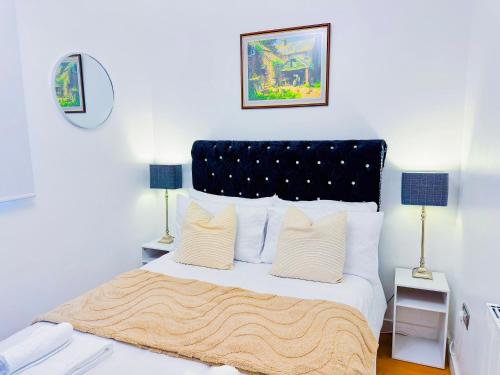a bedroom with a large bed with white sheets and pillows at Elegant 1 bed flat, Sleeps 4, Free parking, Pet friendly, Pudsey, Leeds in Pudsey