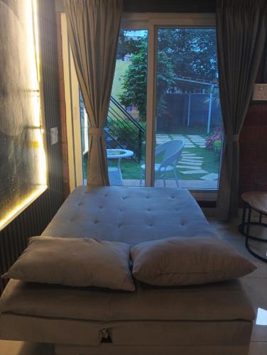 a bed in a room with a large window at Rustic Roots Inn in Bangalore