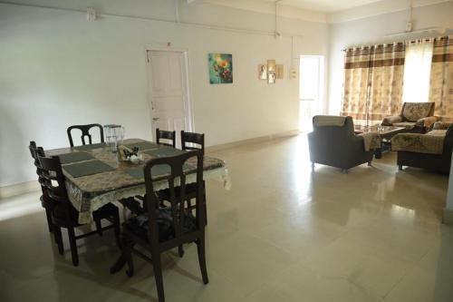 a dining table and chairs in a living room at The Minimalist Nest in Guwahati