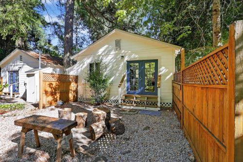 a backyard with a fence and a bench and a house at Cozy Cabin Near Wineries, Harbin Hot Springs cabin in Cobb