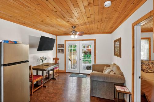 a living room with a couch a table and a refrigerator at Cozy Cabin Near Wineries, Harbin Hot Springs cabin in Cobb