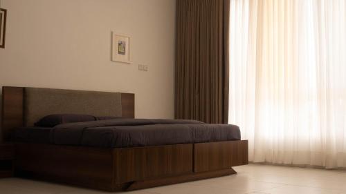 Un dormitorio con una cama y una ventana grande. en 1 Bedroom Haven Ikoyi Apartment with Swimming Pool, en Lagos