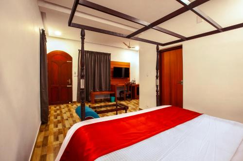 a bedroom with a large bed with a red blanket at Villa Elixir Fort Kochi in Cochin