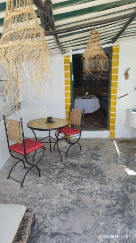 a patio with a table and chairs and a bed at Diabat hostel in Essaouira