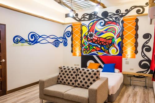 a room with a bed and a painting on the wall at 臺東火車站 黎亞兒民宿Liyar House 青旅客棧 in Taitung City