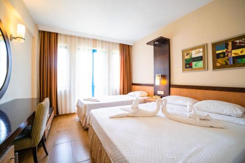 a hotel room with two beds with white sheets at Bezay Hotel in Fethiye