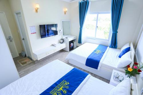 a hotel room with two beds and a tv at Platinum in Xóm Hương Phùng