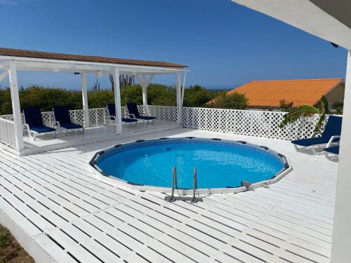 a pool on a deck with chairs and a gazebo at 5 Bedroom Villa with Swimming Pool in Grote Berg