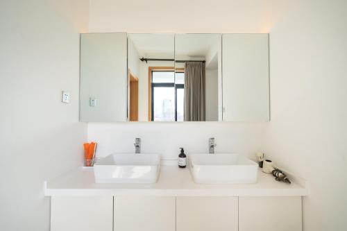 a white bathroom with two sinks and a mirror at ZHome - HaiQi Garden - Four Bedroom Apartment on the Bund with Bund View in Shanghai