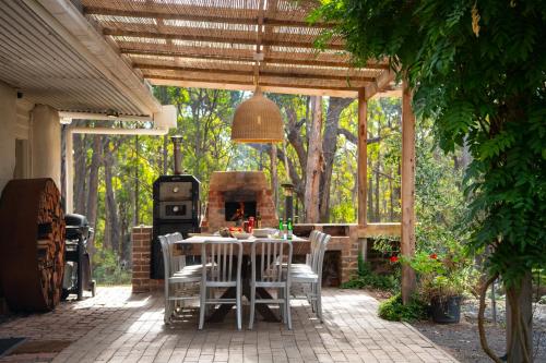 a patio with a table and a fire place at Forest Estate Daylesford 8 Bedrooms 18 pax Pool Sauna Weddings in Glenlyon