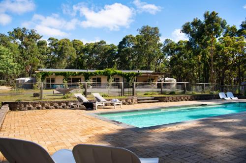a swimming pool with chairs and a house at Forest Estate Daylesford 8 Bedrooms 18 pax Pool Sauna Weddings in Glenlyon