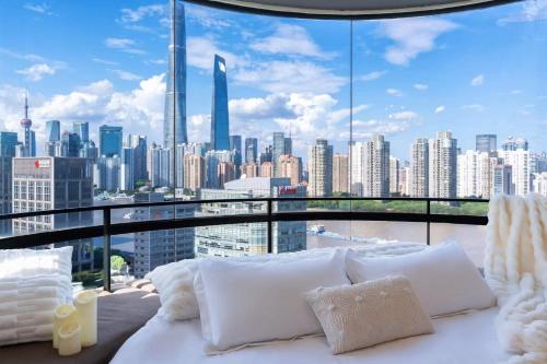 a bedroom with a view of a city skyline at ZHome - HaiQi Garden - Four Bedroom Apartment on the Bund with Bund View in Shanghai